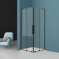 Kabina prysznicowa KOLORADO z czarnymi profilami, w rogu minimalistycznej łazienki, obok fotel z poduszką.png