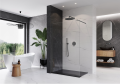 Ścianka prysznicowa LUGO wykonana z transparentnego szkła z wykończeniem w kolorze szczotkowany tytan na tle nowoczesnej łazienki.png