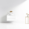 Szafka umywalkowa wisząca LINDA Veldman w kolorze białym, z białym blatem, z białą umywalką oraz złotą baterią ścienną na tle jasnej ściany