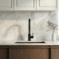 Nowoczesna kuchnia z marmurowym blatem, stalowym zlewem i czarną baterią SIMONA przy oknie, jasne szafki, minimalistyczny styl.