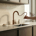 Nowoczesna kuchnia z marmurowym blatem, stalowym zlewem i baterią SIMONA w kolorze miedź szczotkowana - z wyciągniętą wylewką, jasne szafki, minimalistyczny styl.