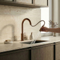 Nowoczesna kuchnia z marmurowym blatem, stalowym zlewem i baterią SIMONA w kolorze miedź szczotkowana - z wyciągniętą wylewką, jasne szafki, minimalistyczny styl.