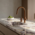 Nowoczesna kuchnia z marmurowym blatem, baterią kuchenną SIMONA w kolorze miedź szczotkowana , zlewem podblatowym i miską limonek.