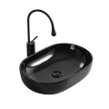 Czarna owalna umywalka w połysku nablatowa ANNA Veldman z czarną baterią