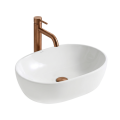 Biała owalna umywalka nablatowa ANNA SLIM Veldman z baterią miedź szczotkowana