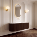 Szafka VERRA 160 z umywalką i złotą szczotkowaną baterią ścienną COSTA w eleganckiej łazience z marmurową ścianą.